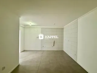Ambiente interno de uma sala com piso de cerâmica e paredes brancas.