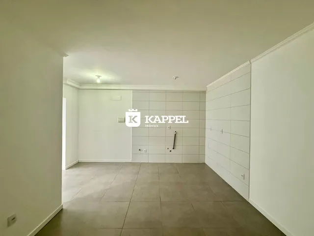 Ambiente interno de uma sala com piso de cerâmica e paredes brancas.