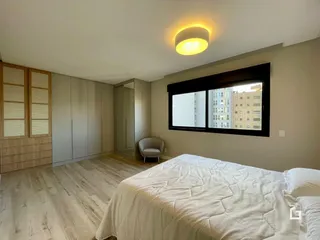 Um quarto com piso de madeira clara e armários embutidos.