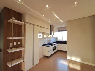 Foto de uma cozinha com armários brancos e bancada escura.