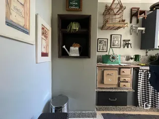 Parede interna com quadros e prateleiras em uma residência.