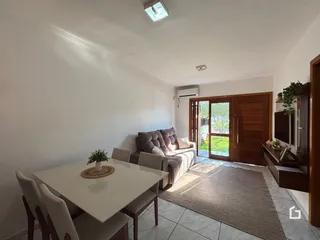 Sala de estar com sofá e mesa de jantar em um apartamento.