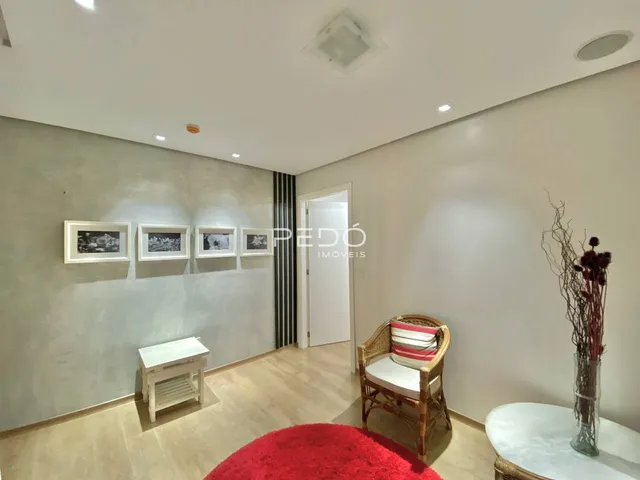 Sala de estar com paredes cinzas e piso de madeira clara.