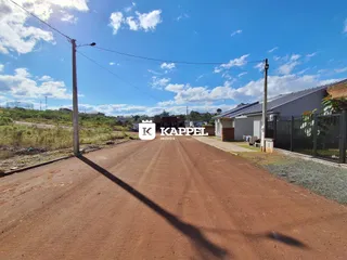 Vista externa da residência em Lajeado, Brasil, com uma estrada de terra no primeiro plano.