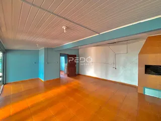 Interior de uma sala com piso de madeira e paredes azul claro.