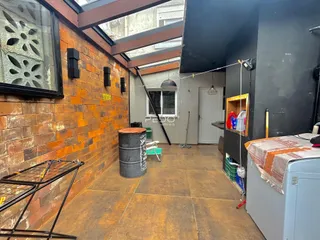Interior de um espaço com paredes de tijolo aparente e teto inclinado.