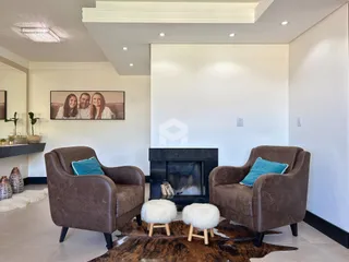 Sala de estar com duas poltronas e lareira em um ambiente moderno.