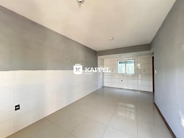 Foto de um corredor interno com piso de porcelanato claro e paredes em tom neutro.