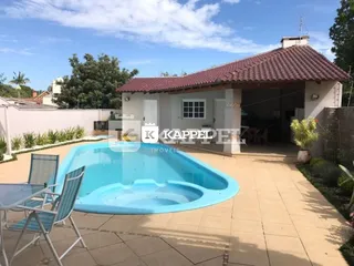 Foto externa mostrando uma piscina com deck em uma propriedade.