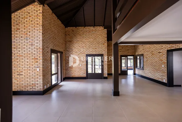 Hall de entrada com paredes de tijolo aparente e piso de cerâmica.