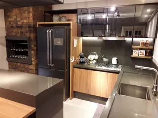 Cozinha moderna com armários escuros e eletrodomésticos de aço inoxidável.