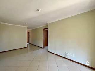 Corredor interno com piso de cerâmica claro.
