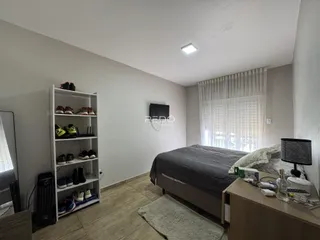 Quarto com cama e estante de prateleiras em um apartamento.