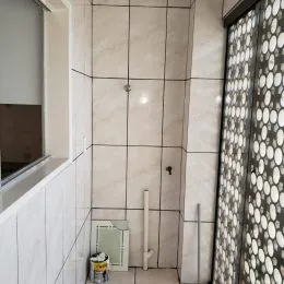 Parede interna com revestimento de azulejos brancos em um ambiente residencial.