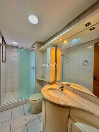 Foto de um banheiro com revestimento cerâmico e bancada de granito claro.