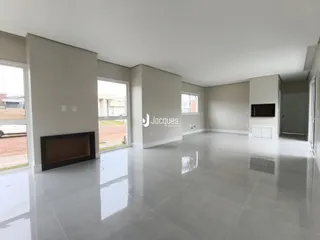 Sala de estar ampla com piso de porcelanato claro e lareira.