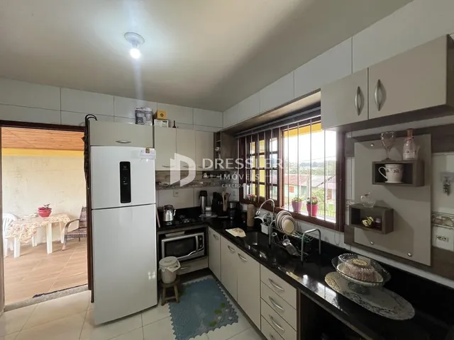 Interior de uma sala com armários brancos e detalhes em madeira.