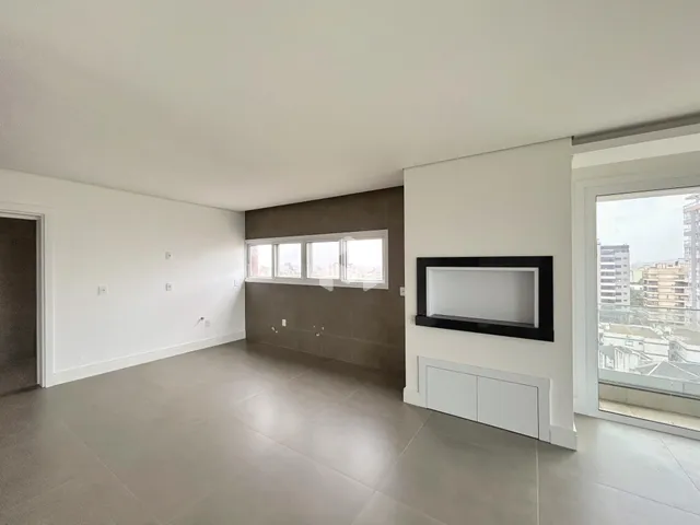 Ambiente interno de uma sala ampla com piso de concreto e grandes janelas.