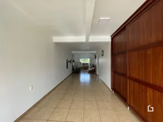Corredor interno com piso de cerâmica e armários de madeira.