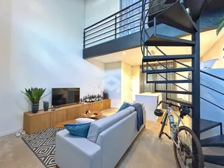 Sala de estar moderna com escadaria e vista.