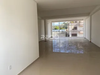 Espaço interno amplo com piso claro e porta de vidro que dá para o exterior.