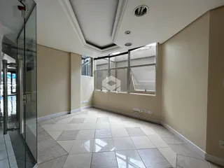 Sala de estar com piso de cerâmica e grande janela.