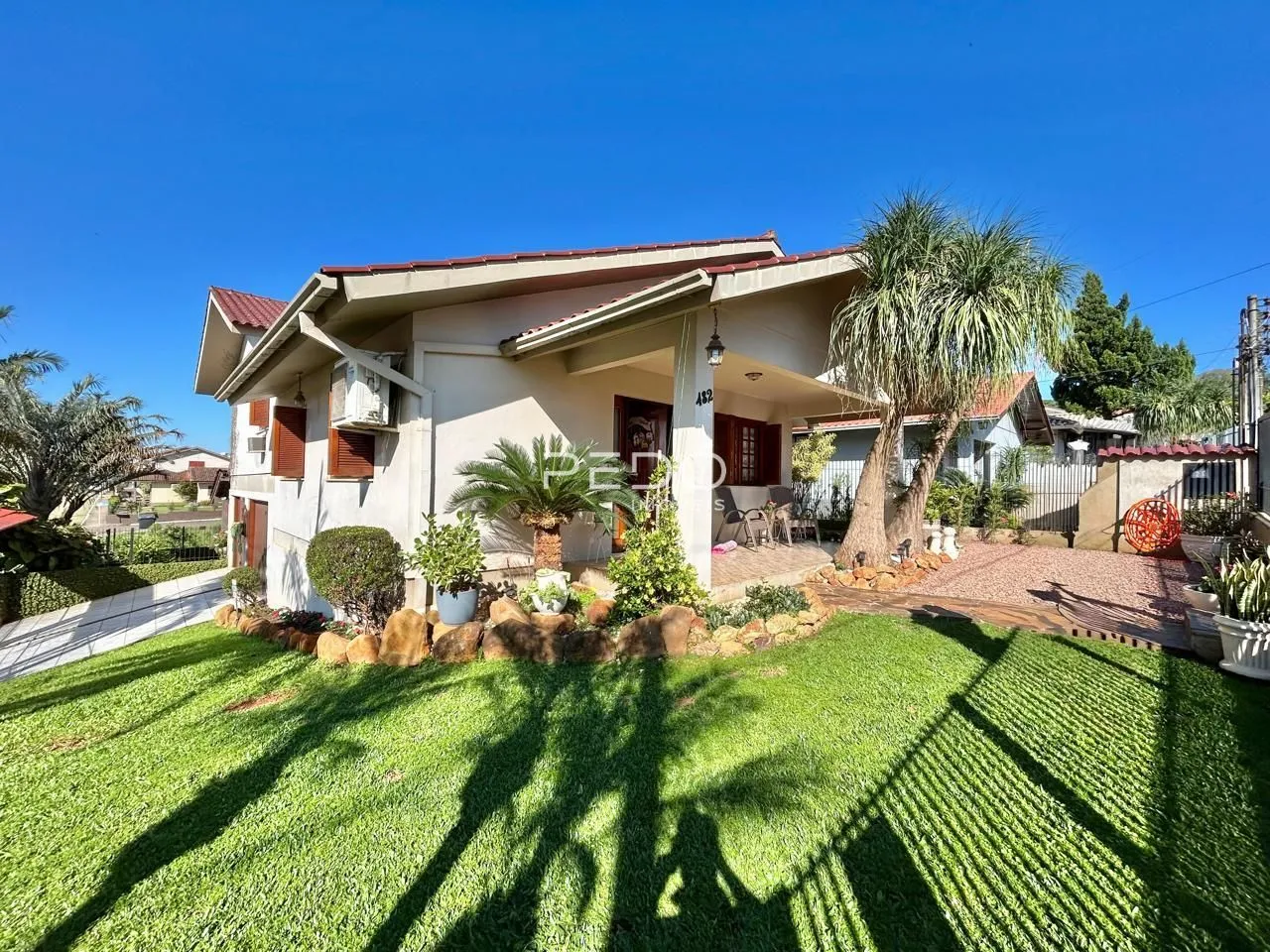 Fachada de uma casa em Lajeado, Brasil, com jardim gramado e vegetação.