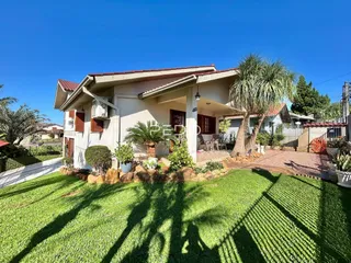 Fachada de uma casa em Lajeado, Brasil, com jardim gramado e vegetação.