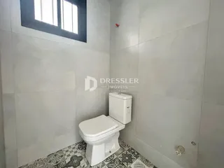 Foto de um banheiro com piso estampado e paredes brancas.