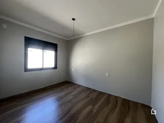 Sala de estar com piso de madeira e paredes cinzas.