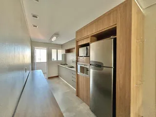 Interior de uma cozinha moderna com armários e geladeira.