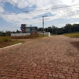 Caminho de tijolos vermelhos leva a uma área externa gramada.