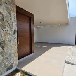Hall de entrada com porta de madeira e parede de pedra na propriedade.