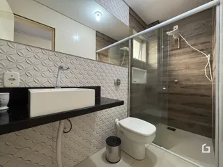 Foto de um banheiro moderno com box de vidro e piso cerâmico.