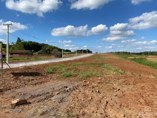Vista panorâmica de uma área de terra com um caminho de terra e postes de energia no meio.