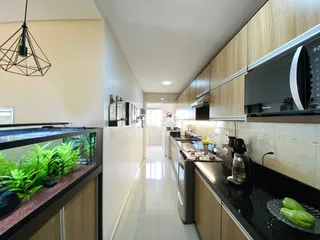 Cozinha moderna com armários de madeira e bancadas escuras.