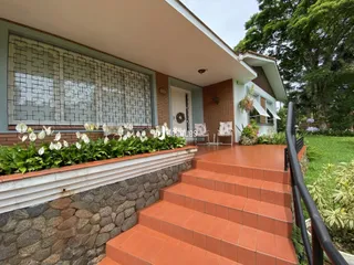 Fachada de uma casa em Lajeado, Brasil, com degraus de tijolo e jardim.