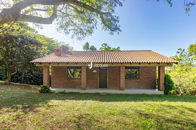 Fachada de casa em tijolo vermelho com telhado de telhas.