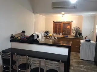 Ambiente interno de uma sala com móveis de madeira escura.