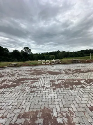 Vista externa da propriedade mostrando uma área pavimentada e gramada.