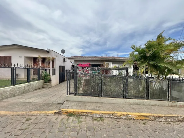 Fachada de uma residência com cerca de ferro e calçada em Lajeado, Brasil.