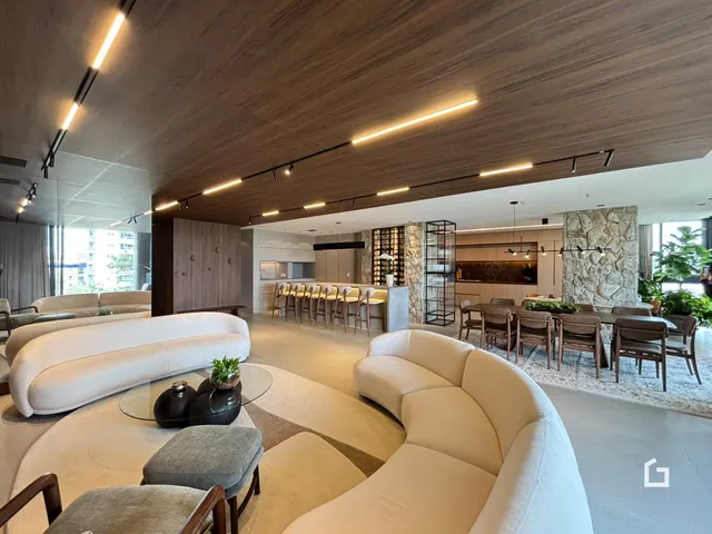Sala de estar ampla com sofás brancos e decoração moderna em um imóvel no Brasil.