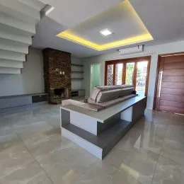 Sala de estar com uma cama grande e piso claro.