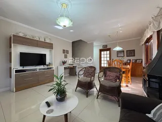 Sala de estar de uma casa em Lajeado, Brasil, com piso claro e móveis de madeira.