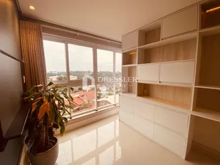 Sala com grandes janelas que oferecem uma vista externa.