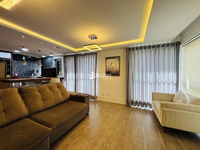 Sala de estar com sofá e piso de madeira clara.