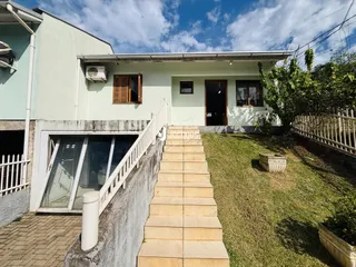Vista da fachada de uma casa em Lajeado, Brasil, com escadaria e jardim.