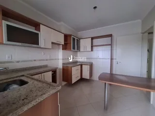 Foto de uma cozinha com armários de madeira e bancada clara.
