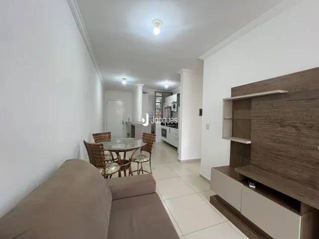 Sala de estar com sofá e mesa de jantar em ambiente claro.