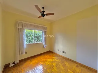 Ambiente interno de uma sala com piso de madeira e janela.